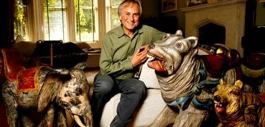 Richard Dawkins sitting among animal figures