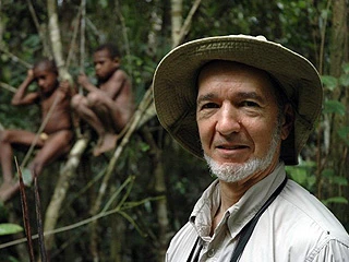 Jared Diamond in a forest with local people in the background