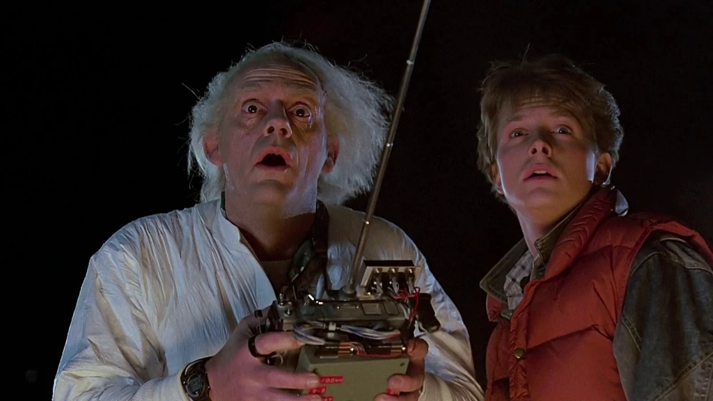 Doc Brown with a remote control and Marty McFly staring in shock at night in Back to the Future