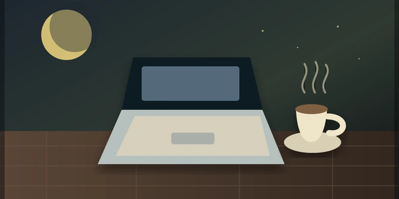 A laptop and a cup of tea on a kitchen table at night