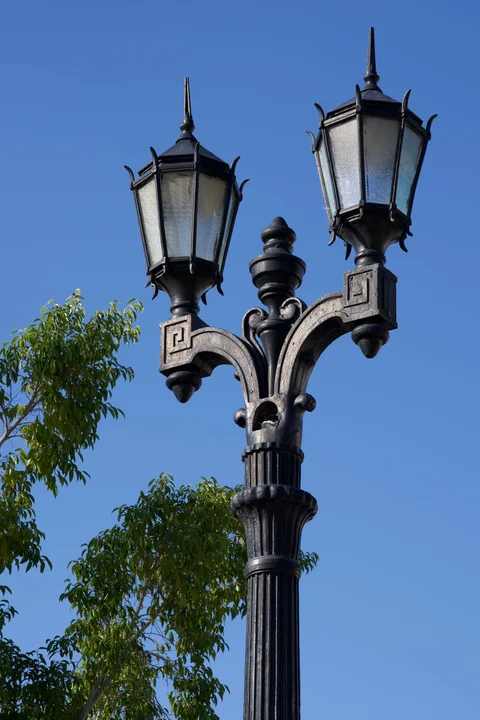 An ornate black double streetlamp against a blue sky in Parque José Martí, Cienfuegos