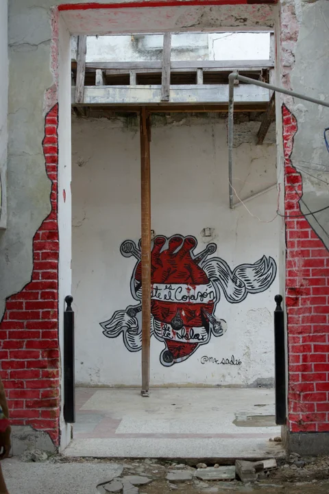 A painted heart inside a stripped doorway framed by exposed brick and a wooden support