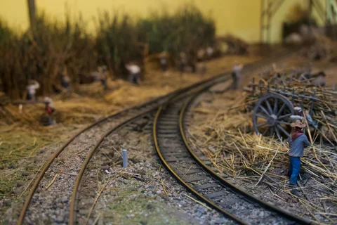A miniature worker and a cart piled with sugar cane beside railway tracks in the Havana Club diorama