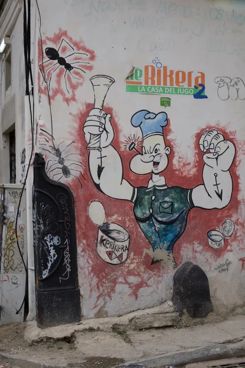 A mural of Popeye holding a glass on a weathered wall in Havana