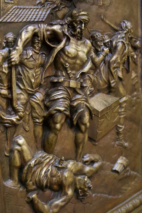 A close view of a sculpted relief showing armed figures on the Capitol doors