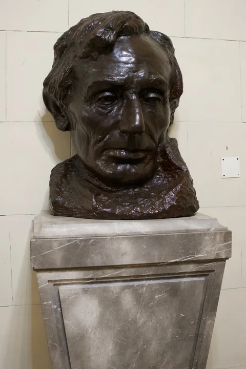 A bronze bust of Abraham Lincoln on a marble pedestal inside the Capitol