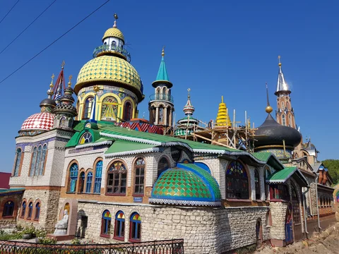 Brightly coloured domes, towers, and tiled roofs of the Temple of All Religions.