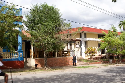 Colourful low buildings and a shaded restaurant terrace along a street in Viñales