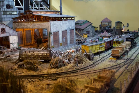 Model wagons and cane carts beside illuminated factory buildings in the Havana Club diorama