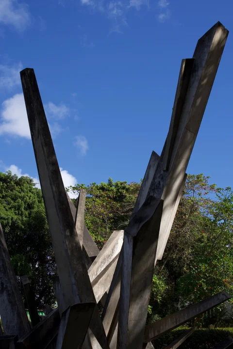 Tall angular concrete sculptures at the Tren Blindado monument against a blue sky