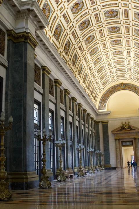 A view along the Capitol’s patterned marble floor towards a doorway beneath the vaulted ceiling