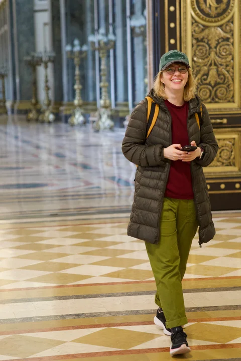 Lena, my beautiful wife, smiling in her green cap beside an ornate doorway inside the Capitol