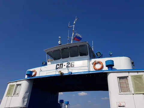 The ferry’s white and blue wheelhouse beneath a clear sky.