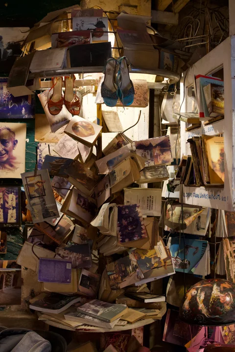 Open books, photographs and colourful shoes suspended inside a Havana workshop