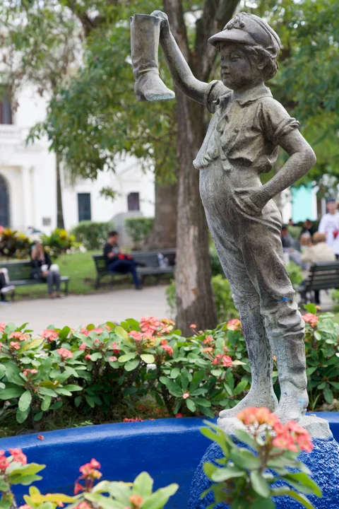 The fountain statue of a boy holding up a boot among flowers in Parque Vidal, Santa Clara