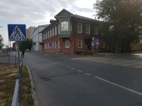 An old wooden house in Kazan, with a projecting balcony above the street corner.