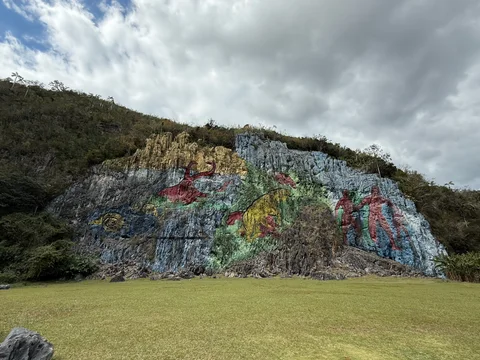 The Mural de la Prehistoria painted across a rock face, with colourful animals and human figures