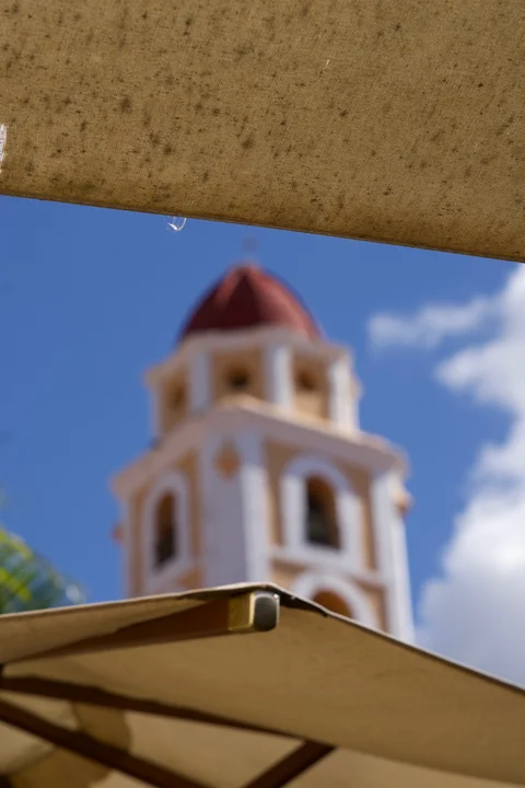 The San Francisco bell tower softly out of focus between sunlit fabric awnings in Trinidad