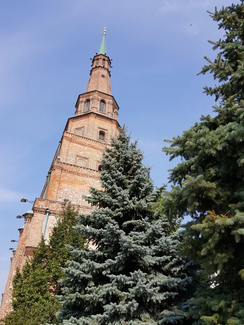 The red-brick Syuyumbike Tower rises above evergreen trees.