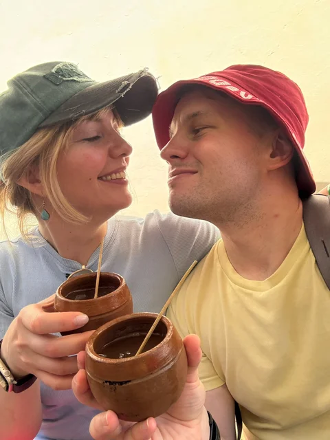 Lena and me holding little clay cups of canchánchara in Trinidad
