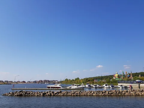 Boats beside a stone riverbank, with the colourful temple visible in the distance.